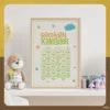 Ein Kinderzimmer mit einem gerahmten Ramadan-Kalender an der Wand, daneben eine Stofftier-Teddybär mit Schleife und Karohose sowie Kinderpflegeprodukte auf einem Regal.